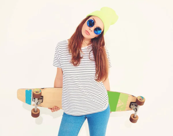 Portre rahat yaz giysileri longboard resepsiyon ile poz sarı beanie şapkalı şık kız modeli. Beyaz izole