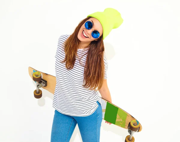 Portre rahat yaz giysileri longboard resepsiyon ile poz sarı beanie şapkalı şık kız modeli. Beyaz izole