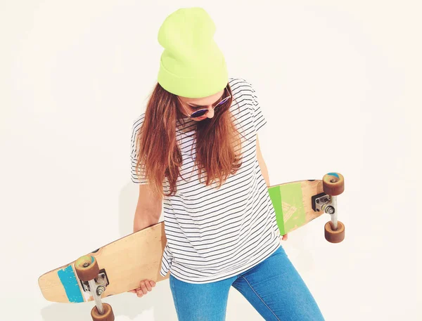 Portre rahat yaz giysileri longboard resepsiyon ile poz sarı beanie şapkalı şık kız modeli. Beyaz izole