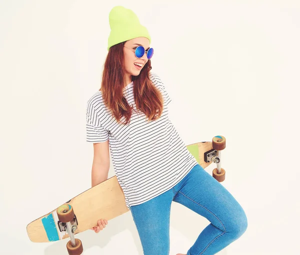 Portre rahat yaz giysileri longboard resepsiyon ile poz sarı beanie şapkalı şık kız modeli. Beyaz izole