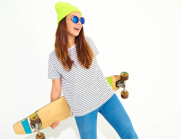 Portre rahat yaz giysileri longboard resepsiyon ile poz sarı beanie şapkalı şık kız modeli. Beyaz izole