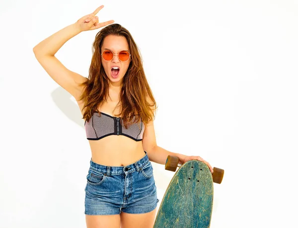 genç şık gülümseyen kız modeli rahat yaz mayo giysileri longboard resepsiyon ile poz. Rock'n roll işaret gösteren