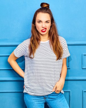 Gündelik yaz kıyafetleri kırmızı dudaklar, mavi duvara yakın poz ile genç şık kız modeli