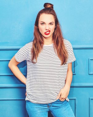 Gündelik yaz kıyafetleri kırmızı dudaklar, mavi duvara yakın poz ile genç şık kız modeli