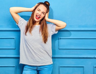 Gündelik yaz kıyafetleri kırmızı dudaklar, mavi duvara yakın poz ile genç şık kız modeli