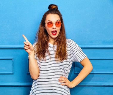 Gündelik yaz kıyafetleri kırmızı dudaklar, mavi duvara yakın poz ile kız modeli. Akılda alır iyi fikir nasıl proje geliştirmek, yükseltir parmak, ses ve düşüncelerini ifade etmek istiyor