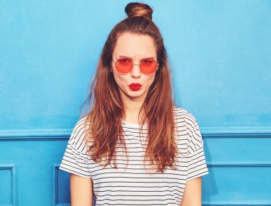 Gündelik yaz kıyafetleri kırmızı dudaklar, mavi duvara yakın poz ile genç şık kız modeli