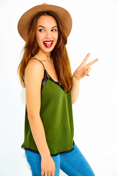 カジュアルな夏緑服と赤い唇 ピースサインと彼女の舌を示す茶色の帽子でスタイリッシュな少女モデル — ストック写真