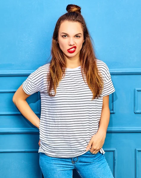 赤い唇 青い壁に近いポーズでカジュアルな夏服でスタイリッシュな少女モデル — ストック写真