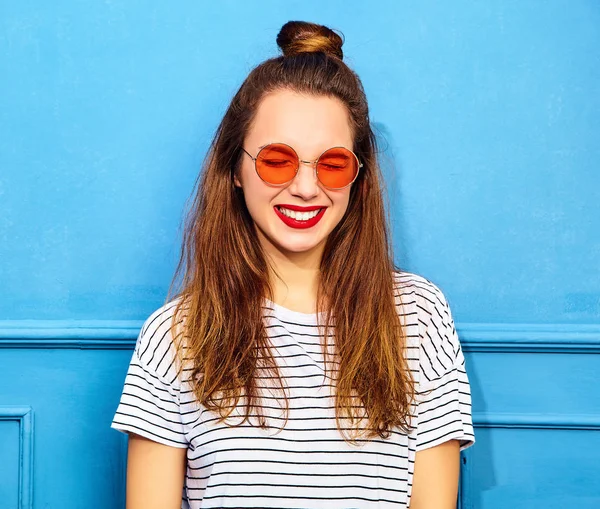 Gündelik yaz kıyafetleri kırmızı dudaklar, mavi duvara yakın poz ile genç şık kız modeli. Mutlu ve kapalı gözler