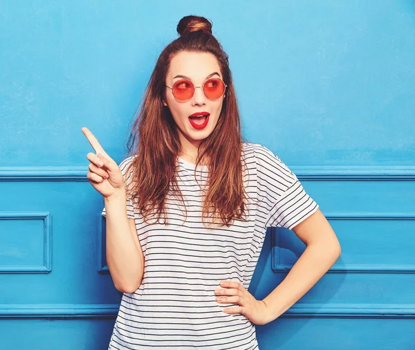 Gündelik yaz kıyafetleri kırmızı dudaklar, mavi duvara yakın poz ile kız modeli. Akılda alır iyi fikir nasıl proje geliştirmek, yükseltir parmak, ses ve düşüncelerini ifade etmek istiyor