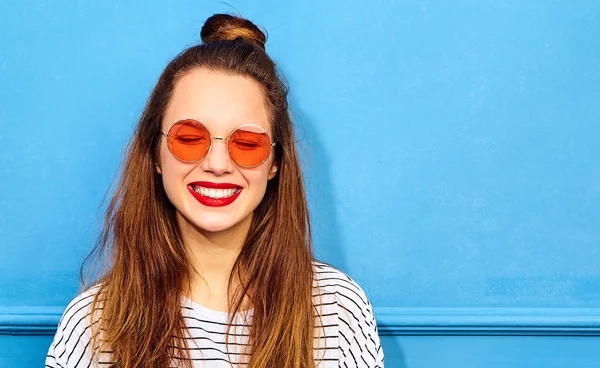 Gündelik yaz kıyafetleri kırmızı dudaklar, mavi duvara yakın poz ile genç şık kız modeli