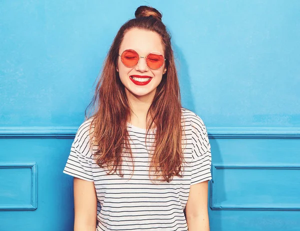 Gündelik yaz kıyafetleri kırmızı dudaklar, mavi duvara yakın poz ile genç şık kız modeli