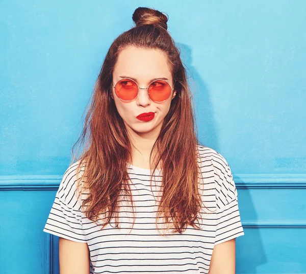 Gündelik yaz kıyafetleri kırmızı dudaklar, mavi duvara yakın poz ile genç şık kız modeli