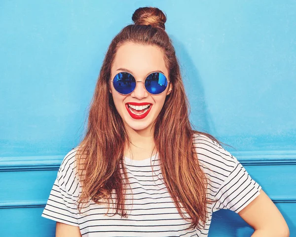 年轻时尚的女孩在休闲夏天的衣服 红色的嘴唇 摆在蓝色的墙壁附近的模型 — 图库照片