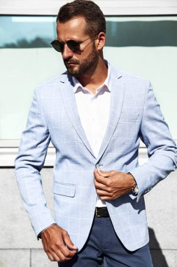 Seksi yakışıklı işadamı manken portresi sokak arka plan üzerinde poz zarif mavi takım elbise giymiş. Metroseksüel