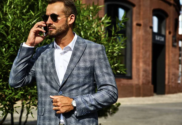 セクシーなハンサムな実業家ファッションモデルの肖像画は通りにスマート フォンのビジネス モバイルで会話を持つ上品な市松模様のスーツに身を包んだ メトロ セクシャル — ストック写真