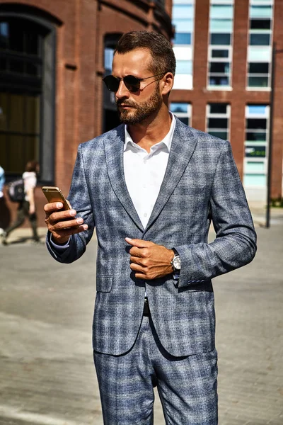 セクシーなハンサムな実業家ファッションモデルの肖像画は通りにスマート フォンのビジネス モバイルで会話を持つ上品な市松模様のスーツに身を包んだ メトロ セクシャル — ストック写真