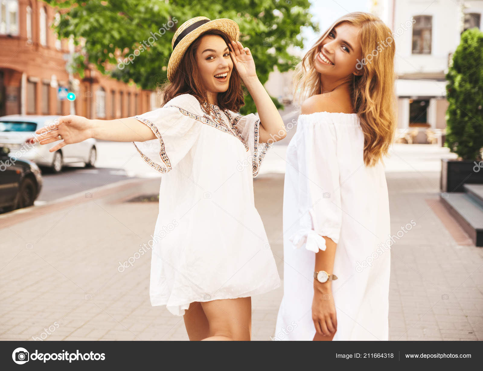 Two chicks in pretty summer outfits walk across the street