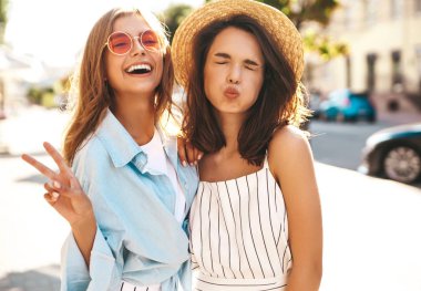 İki genç şık hippi esmer ve sarışın Bayan modelleri yaz güneşli günde sokak arka plan üzerinde poz hipster giysileri moda portre. Hiç makyaj