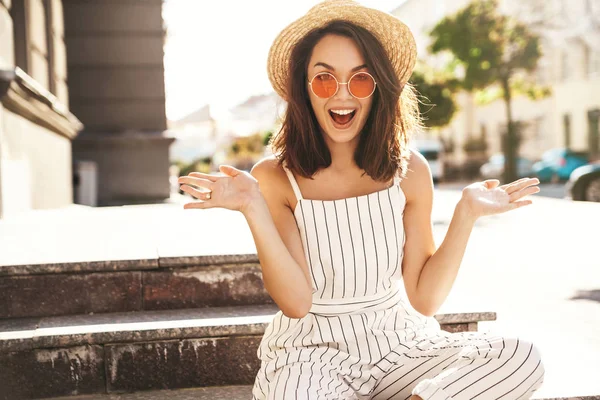 Yaz hipster giysileri sokak arka merdivenlerde oturan güzel şirin esmer genç modeli. Karşılaştırma kavramı, bir şey benzer ürün seçimi için düz iki elle görüntülemek