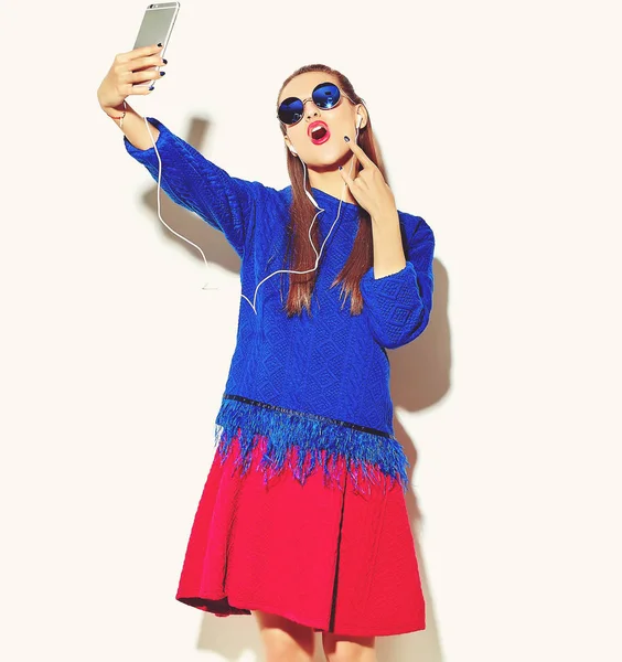 güzel mutlu sevimli gülümseyen seksi esmer kadın rahat yaz renkli giysileri kızı kırmızı dudaklar ile smartphone ve gösteren kaya beyaz yapma selfie fotoğrafa bir rulo işareti izole