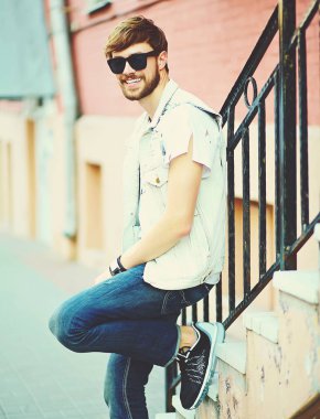 Komik gülümseyen hipster yakışıklı adam şık yaz giysileri güneş gözlüğü sokakta