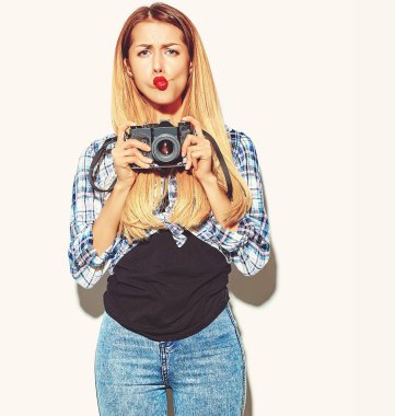 Kırmızı dudaklar ile rahat yaz hipster giysili güzel mutlu sevimli sarışın kadın kızı fotoğraf holding retro fotoğraf kamera yapım ördek yüz alır.