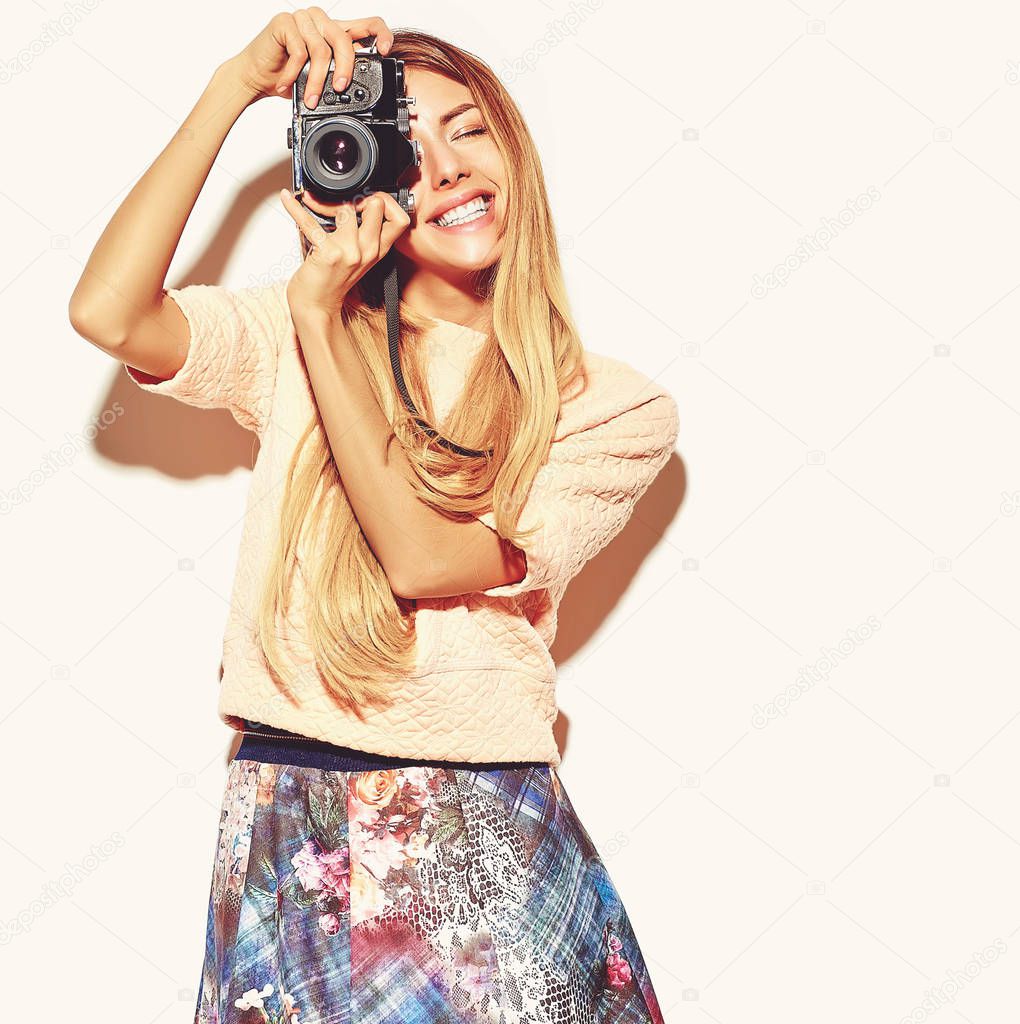 beautiful happy cute blond woman girl in casual summer hipster clothes takes photos holding retro photographic camera, isolated on a white 
