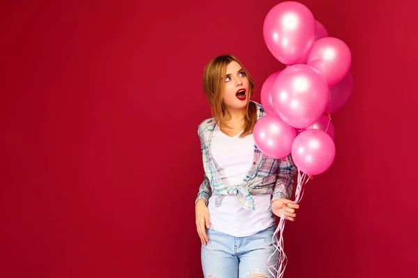 兴奋的年轻女孩摆姿势在时髦的夏天格子衬衫衣服 妇女模型与粉红色的气球在红色背景 圣妇女节 新年快乐 生日节日派对 — 图库照片