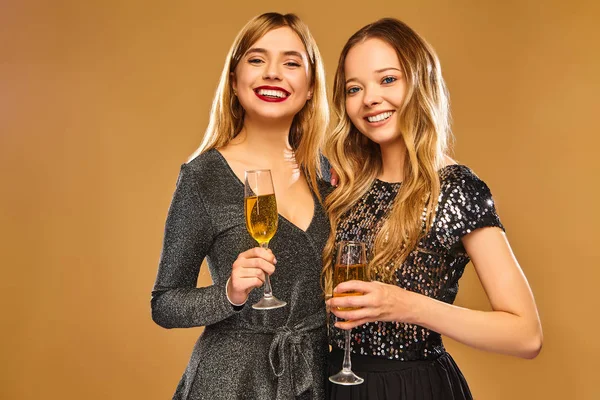 美しい金髪の女性は ファッションのパーティーで楽しんで新しい Year Models を祝います 幸せな笑みを浮かべて服の少女たちスタイリッシュな華やかなシャンパン グラスで 金色の背景に分離 — ストック写真
