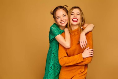 Son moda yazlık giysiler içinde poz iki genç güzel sarışın gülümseyen hipster kızlar. Altın arka plan üzerinde izole kaygısız kadınlar. Delirmek olumlu modelleri