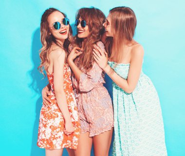 Üç genç güzel gülümseyen hippi kız trendy yaz casual elbise ve güneş gözlüğü. Seksi kaygısız kadın mavi duvara yakın poz. Delirmek olumlu modelleri