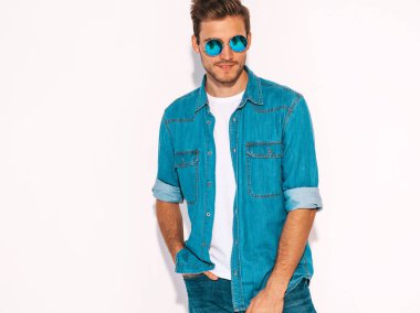 Portre yakışıklı gülümseyen şık hipster lumbersexual işadamı modeli kot elbise giymiş. Moda erkek güneş gözlüğü takıyor. Beyaz izole