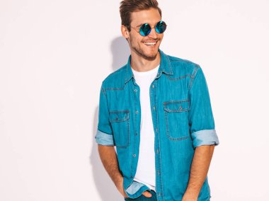 Portre yakışıklı gülümseyen şık hipster lumbersexual işadamı modeli kot elbise giymiş. Moda erkek güneş gözlüğü takıyor. Beyaz izole