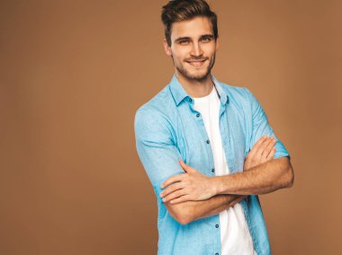 Portre yakışıklı gülümseyen şık hipster lumbersexual işadamı modeli kot elbise giymiş. Moda adam. Altın arka plan üzerinde poz