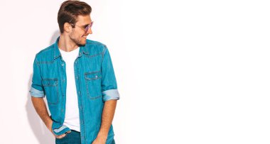 Portre yakışıklı gülümseyen şık hipster lumbersexual işadamı modeli kot elbise giymiş. Moda erkek güneş gözlüğü takıyor. Beyaz izole