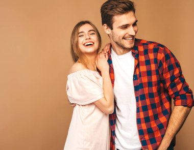 Gülümseyen güzel kız ve onun yakışıklı erkek gülüyor. Mutlu neşeli Family.Valentine'nın günü. Bej duvara poz. Sarılma