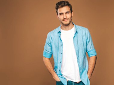 Portre yakışıklı gülümseyen şık hipster lumbersexual işadamı modeli kot elbise giymiş. Moda adam. Altın arka plan üzerinde poz