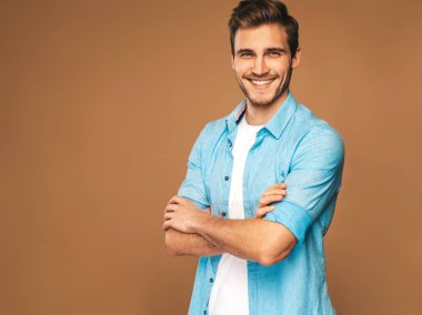 Portre yakışıklı gülümseyen şık hipster lumbersexual işadamı modeli kot elbise giymiş. Moda adam. Altın arka plan üzerinde poz