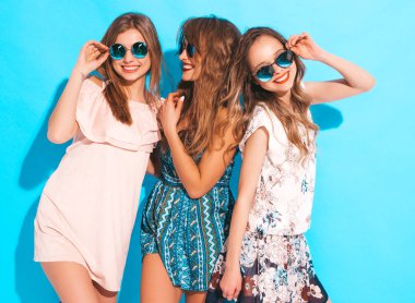 Üç genç güzel gülümseyen hippi kız trendy yaz renkli elbiseler. Mavi izole güneş gözlüklü seksi kaygısız kadın. Delirmek olumlu modelleri