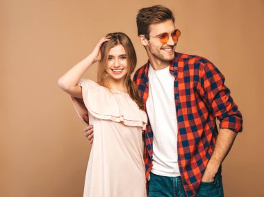 Gülümseyen güzel kız ve onu gülerken yakışıklı erkek portresi. Mutlu neşeli aile. güneş gözlüğü. Sevgililer günü. Bej duvara poz. Sarılma