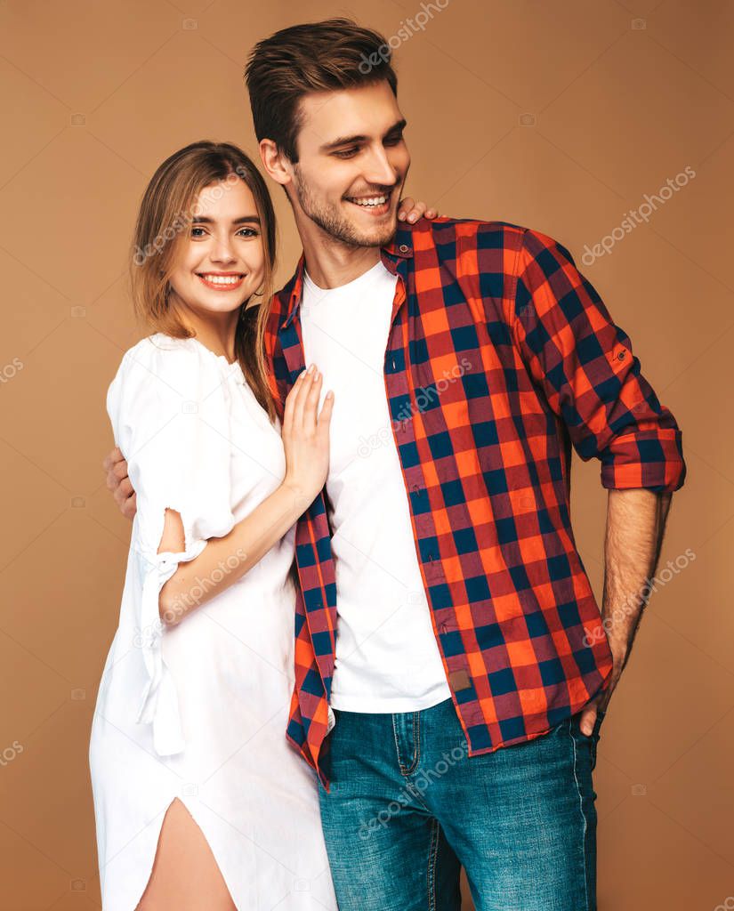Portrait of Smiling Beautiful Girl and her Handsome Boyfriend laughing.Happy Cheerful Family.Valentine's Day. Posing on beige wall. Hugging