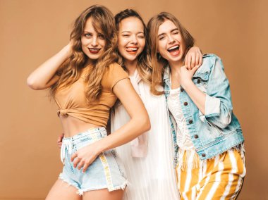 Üç genç güzel gülümseyen hippi kız trendy yaz rahat kıyafetler. Altın arka plan üzerinde poz seksi kaygısız kadın. Delirmek olumlu modelleri