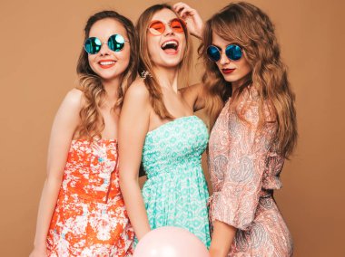 Üç yaz hipster güzel kadınların gülümseyen Giydir. Altın arka plan üzerinde poz kızlar. Modelleri renkli hava balonları ile. Eğleniyor, kutlama Doğum günü veya tatil parti için hazır