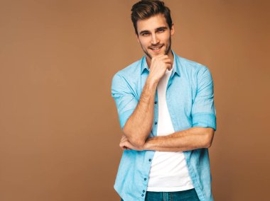 ortrait yakışıklı gülümseyen şık hipster lumbersexual işadamı modeli mavi gömlek elbise giymiş. Altın arka plan üzerinde poz moda adam