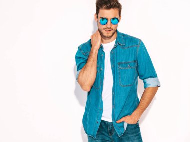Portre yakışıklı gülümseyen şık hipster lumbersexual işadamı modeli kot elbise ve güneş gözlüğü giymiş. Moda adam beyaz izole