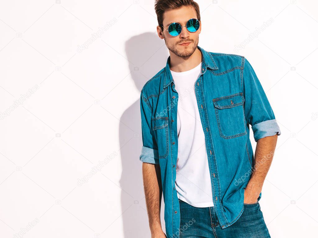 Portrait of handsome smiling stylish hipster lumbersexual businessman model wearing jeans clothes and sunglasses. Fashion man isolated on white