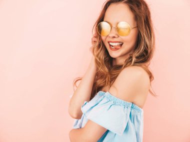 Yuvarlak güneş gözlüğü güzel gülümseyen şirin model portresi. Yaz hipster renkli giysileri kızı. Model pembe arka plan poz
