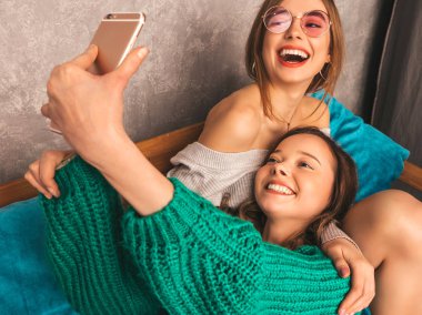 İki genç gülümseyen güzel kızlar trendy yaz hipster giysileri güzel. Seksi kaygısız kadın iç ve alma selfie poz. Olumlu modelleri smartphone ile eğleniyor